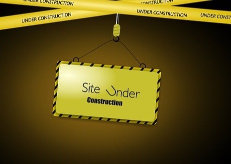 image which says underconstruction on a yellow sign with a brown background